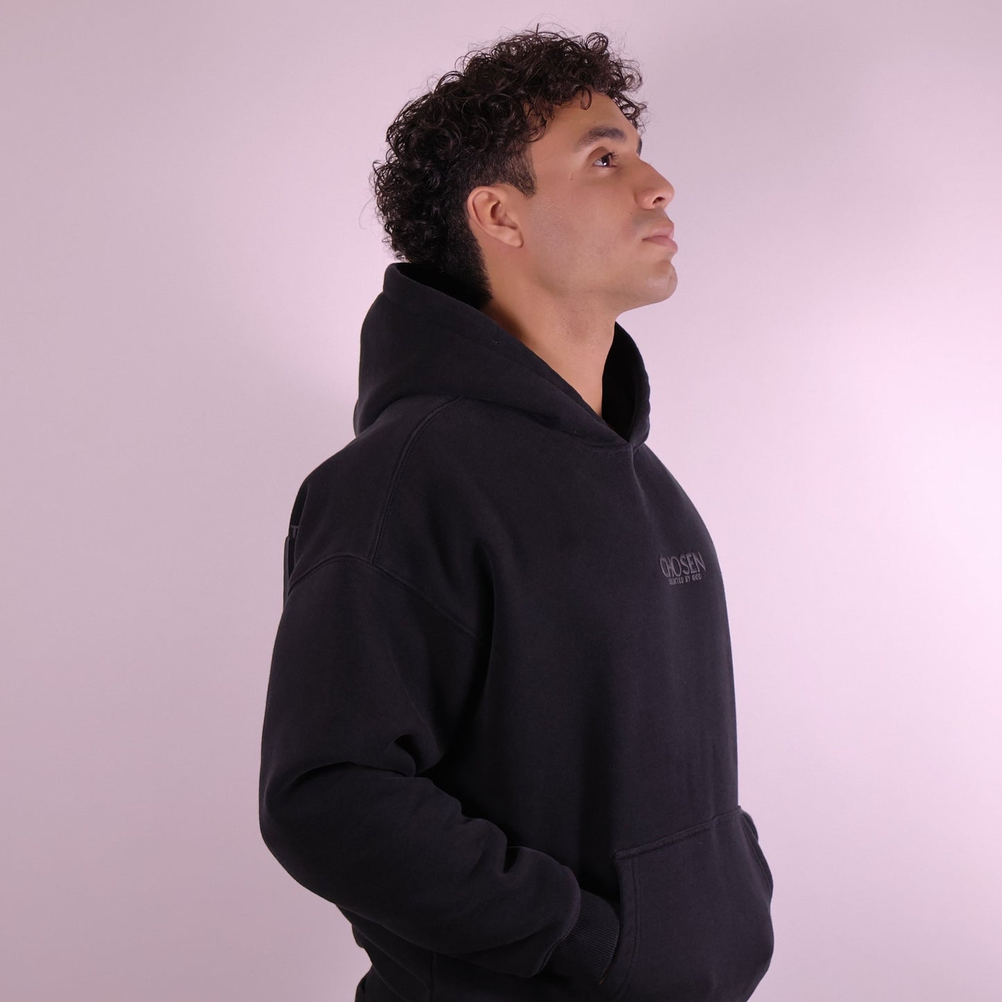 Close-up of ‘We Are His Masterpiece’ script on black hoodie by We Are Chosen Apparel