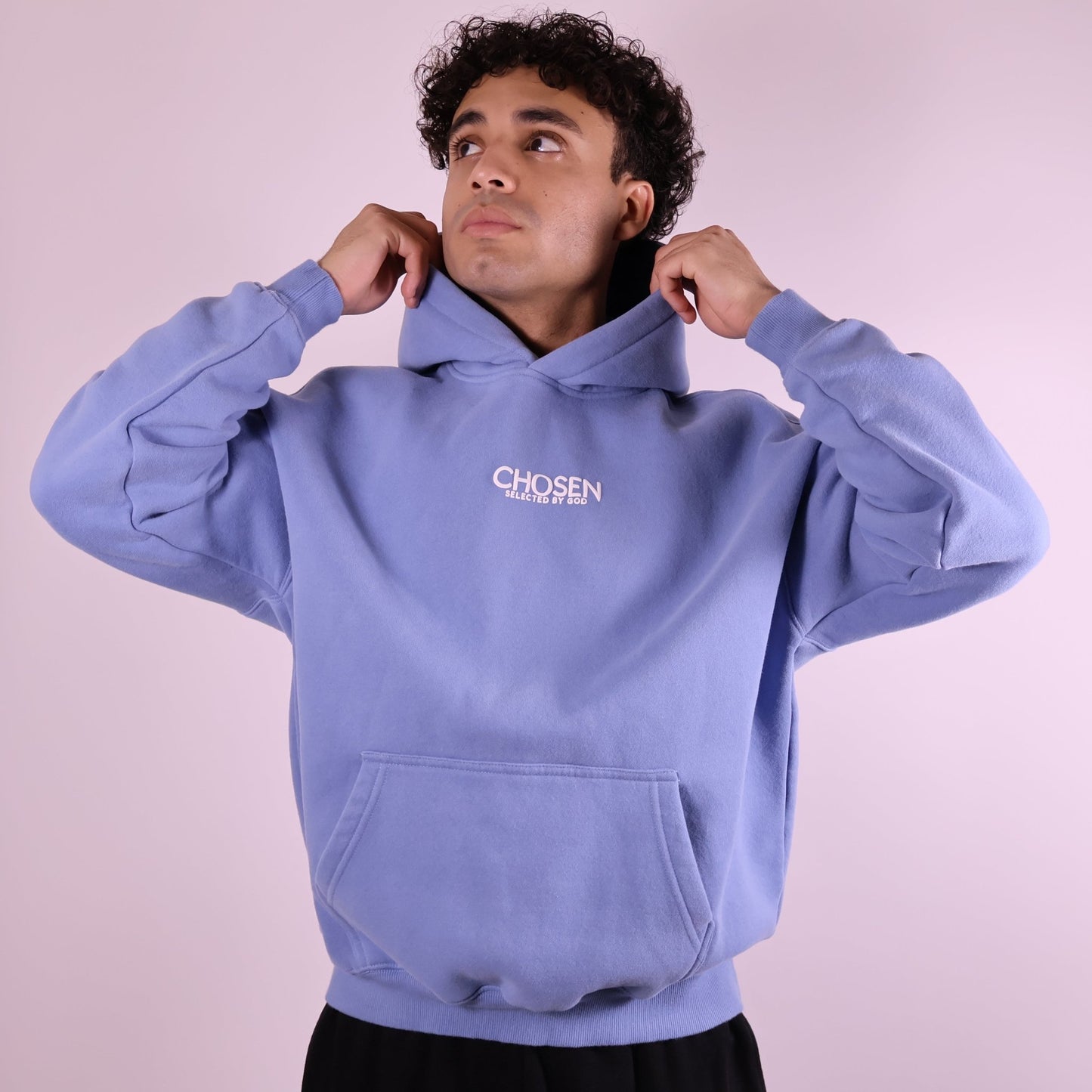 Close-up of ‘We Are His Masterpiece’ script on medium blue hoodie by We Are Chosen Apparel