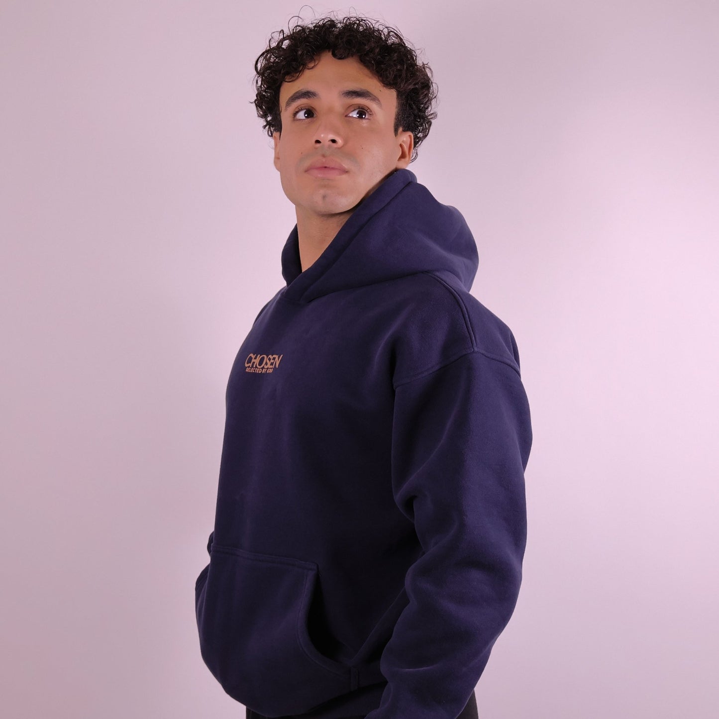 Close-up of ‘We Are His Masterpiece’ script on midnight blue hoodie by We Are Chosen Apparel