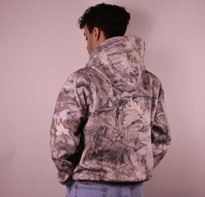 Person wearing a camouflage jacket against a plain background