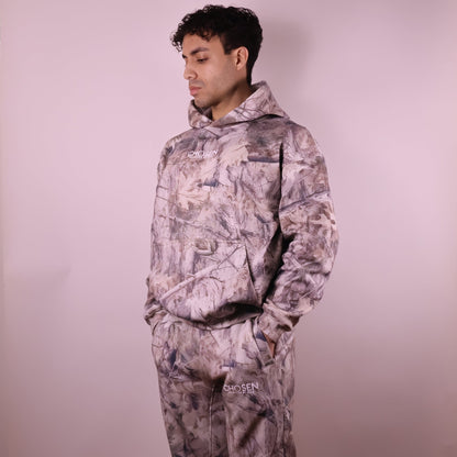Person wearing a camouflage outfit with a plain background